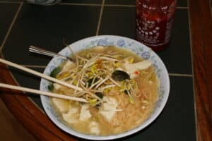 Bowl of Vietnamese pho noodle soup with fresh herbs