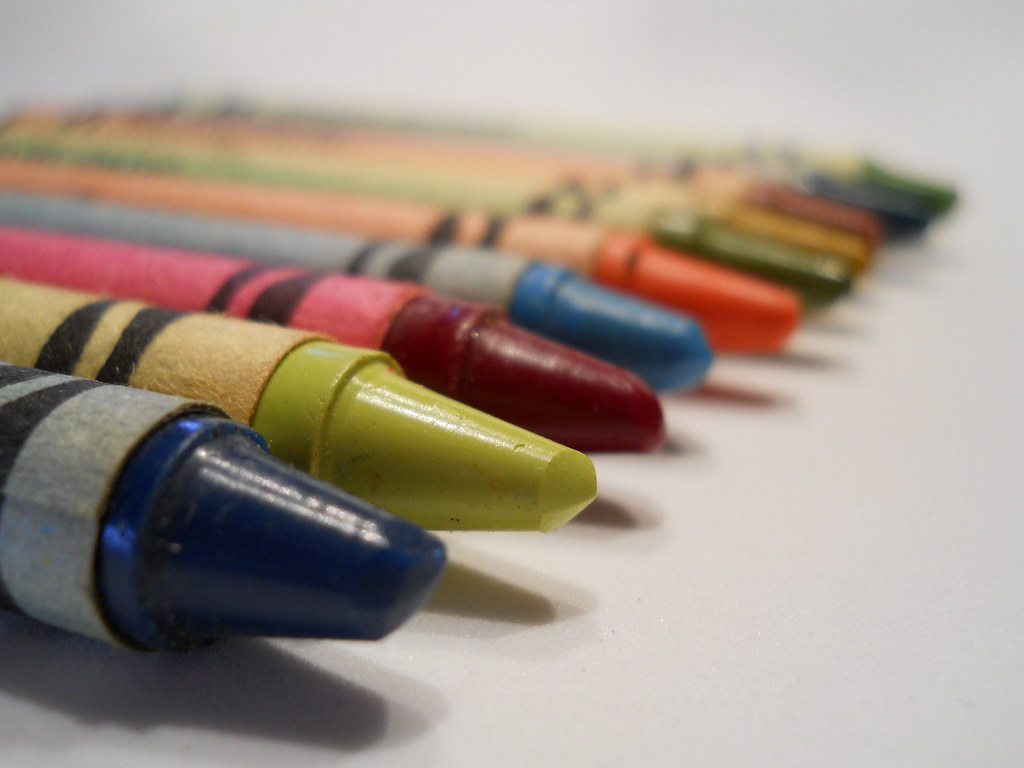 Colorful crayons arranged in a rainbow, representing an indoor family activity